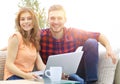 Young couple of students uses a laptop sitting on sofa Royalty Free Stock Photo