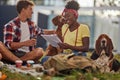 A young couple is studying while sitting on the grass in the park with their dogs. Friendship, rest, pets, picnic Royalty Free Stock Photo