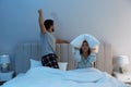 Young couple suffering from noisy neighbours in bed at home