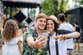 Young couple at summer festival, taking selfie with smartphone. Royalty Free Stock Photo
