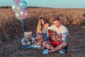 A young couple summer sitting in wheat field. Romantic evening, outdoor recreation. The concept of love music guitar Royalty Free Stock Photo