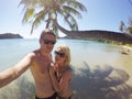 Young couple sunbathing in a sea near palm at wild beach Royalty Free Stock Photo