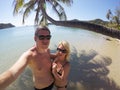 Young couple sunbathing in a sea near palm at wild beach Royalty Free Stock Photo