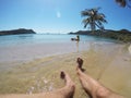 Young couple sunbathing in a sea near palm at wild beach Royalty Free Stock Photo