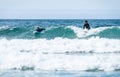 Young couple surfing with surfboard on waves in Atlantic ocean Royalty Free Stock Photo