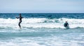 Young couple surfing with surfboard on waves in Atlantic ocean Royalty Free Stock Photo