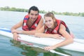 Young couple swiming with paddle board in lake