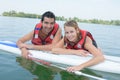 Young couple swiming with paddle board in lake