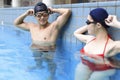 Young couple swimmers preparing to race at the swimming pool Royalty Free Stock Photo