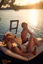 A young couple in swimsuit chatting while enjoying the sunset on the river bank. Summer, river, vacation Royalty Free Stock Photo
