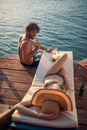 A young couple in swimsuit having a good while sunbathing on the river bank. Summer, river, vacation Royalty Free Stock Photo