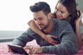 Young couple with tablet lying prone on carpet Royalty Free Stock Photo