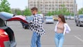 Young couple taking out travel suitcases fron car trunk while standing on the parking. Trip, transportation Royalty Free Stock Photo