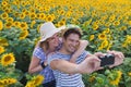 Young couple taking photos in sunflower field Royalty Free Stock Photo