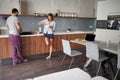 Young couple talking and enjoying together in kitchen while preparing food. lifestyle, modern, casual living concept