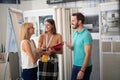 Young couple talking with sales manager abut interior decor at ceramic tiles store. choosing, buying, selling concept Royalty Free Stock Photo