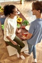 Young couple talking and smiling while preparing healthy meal in the kitchen together. Vegetarianism, healthy food Royalty Free Stock Photo