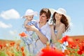 Young couple and their baby-girl in poppy field Royalty Free Stock Photo