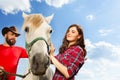 Young couple with their horse against the blue sky Royalty Free Stock Photo