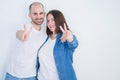 Young couple together over white isolated background smiling with happy face winking at the camera doing victory sign Royalty Free Stock Photo