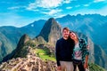 Young couple of tourist in Machu Picchu. They are together, happy and relaxed.