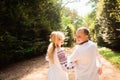 A young couple in a traditional Ukrainian clothing whith bouquet enjoy the sunny day at Stryisky Park in Lviv. Backview Royalty Free Stock Photo