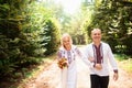 A young couple in a traditional Ukrainian clothing whith bouquet walking in the sunny park