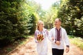 A young couple in a traditional Ukrainian clothing whith bouquet walking in the sunny park