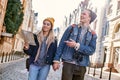 Young couple of travel bloggers are trying to navigate by map in unfamiliar city