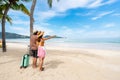 Young couple traveler with luggage relaxing and enjoying at beautiful tropical sand beach, Summer vacation and Travel concept Royalty Free Stock Photo