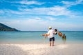 Young couple traveler relaxing and enjoying at beautiful tropical white sand beach with transparent sea, Summer vacation Royalty Free Stock Photo