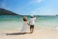 Young couple traveler relaxing and enjoying at beautiful tropical white sand beach with wave foam and transparent sea, Summer Royalty Free Stock Photo