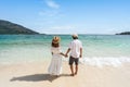 Young couple traveler relaxing and enjoying at beautiful tropical white sand beach with wave foam and transparent sea, Summer Royalty Free Stock Photo