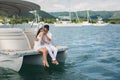 Young couple is traveling on a yacht in the Indian ocean. Man and a woman sit on the edge of the boat and kiss. Royalty Free Stock Photo