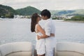 Young couple is traveling on a yacht in the Indian ocean. Man and a woman stand on the edge of the boat and kiss.