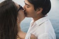 Young couple is traveling on a yacht in the Indian ocean. Man and a woman stand on the edge of the boat and kiss.