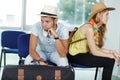 young couple travellers bored with waiting for departure