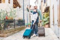 A young couple travelling with luggage and walking in an old italian town