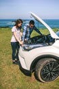 Young couple tries to fix the broken down car Royalty Free Stock Photo