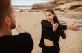 Young couple two friends warming up and doing hands stretching exercises, working out on sand ocean beach outdoor Royalty Free Stock Photo