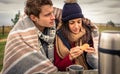 Young couple under blanket eating muffin outdoors Royalty Free Stock Photo