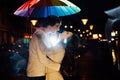 Young couple under an umbrella kisses at night on a city street. Royalty Free Stock Photo