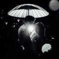 Young couple under an umbrella kisses at night on a city street. Royalty Free Stock Photo