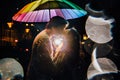 Young couple under an umbrella kisses at night on a city street. Royalty Free Stock Photo