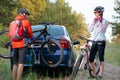 Young Couple Unmounting Mountain Bikes from Bike Rack on the Car. Adventure and Family Travel Concept. Royalty Free Stock Photo