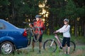 Young Couple Unmounting Mountain Bikes from Bike Rack on the Car. Adventure and Family Travel Concept. Royalty Free Stock Photo