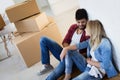 Young couple unpacking cardboard boxes at new home moving in concept Royalty Free Stock Photo