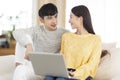 Young couple using computer together in the living room.Looking at each other Royalty Free Stock Photo