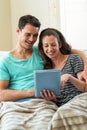 Young couple using a digital tablet on sofa