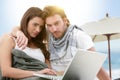 Young couple using laptop on the beach Royalty Free Stock Photo